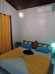 um quarto com uma cama grande com um cobertor amarelo em Blue Sapphire guest house em Caucaia