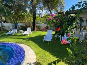 um quintal com cadeiras azuis e uma piscina em Blue Sapphire guest house em Caucaia