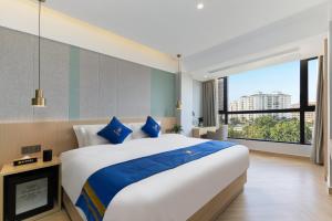 a bedroom with a large bed and a large window at Super 8 Selected Hotel Sanya Bay Coconut Dream Corridor in Sanya