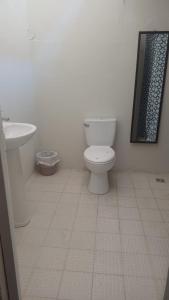 een witte badkamer met een toilet en een wastafel bij Hotel villa 15 in Las Victorias