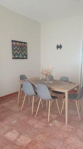 een eettafel met stoelen en een houten tafel bij Hotel villa 15 in Las Victorias