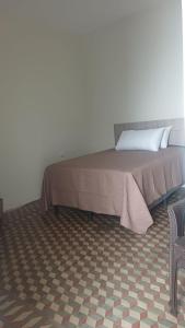 een bed in een kamer naast een stoel bij Hotel villa 15 in Las Victorias +8 foto's