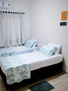 two beds sitting next to each other in a room at Hotel Real Ipiranga in Três Marias +9 photos
