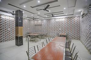 Habitación con mesas, sillas y ventilador de techo. en Hotel O Vrishti Hotels by Ananda, en Sūrajpur