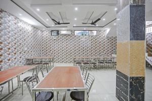 Habitación con mesas, sillas y pared de ladrillo. en Hotel O Vrishti Hotels by Ananda, en Sūrajpur 24 fotos más