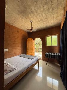 een slaapkamer met een groot bed en een raam bij Time Travellers in Auroville +109 foto's