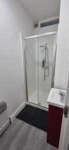 a bathroom with a glass shower and a sink at Private Room in Eglantine Avenue in Central Belfast in Belfast