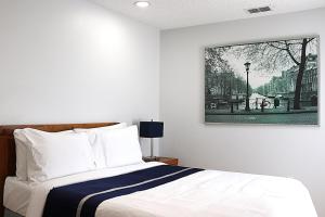 レイクランドにあるIndigo City Escapeのベッドと壁に絵が飾られた寝室