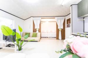 a living room with a couch and a room with a bed at 9 min to Yokkaichi Tomida STN House - Vacation STAY 14165 in Yokkaichi