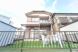 Nishi-hinoにあるYokkaichi City - House - Vacation STAY 68977vの白い椅子が2脚前にある建物