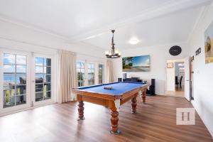 Una sala de estar con una mesa de billar. en Luxury Waterfront Getaway, en Toukley