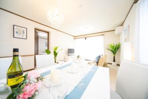 a dining room with a white table with a bottle of wine at Sumoto - House - Vacation STAY 83638v in Sumoto