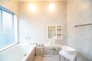 a bathroom with a tub and a sink and a mirror at Sumoto - House - Vacation STAY 83638v in Sumoto +38 photos