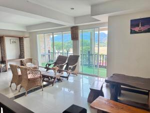 a living room with chairs and a table and windows at Maekhong Delta Boutique Hotel in Mae Sai
