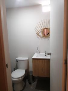 a bathroom with a toilet and a sink and a mirror at Hampiwasi in Miraflores