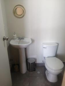a bathroom with a white toilet and a sink at Hampiwasi in Miraflores