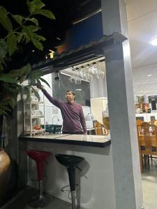 a man standing behind a counter in a kitchen at Happy House Sài Gòn in Ho Chi Minh City