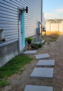 a building with a door and steps next to a house at Comfortable Two Bed Basement With Free WiFi, Laundry and Private Entry in Regina