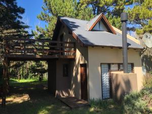 ein kleines weißes Haus mit einer Holzveranda in der Unterkunft Azul Marina in Mar Azul