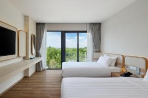 Ένα ή περισσότερα κρεβάτια σε δωμάτιο στο Phetara Hotel Mahachai by PCL