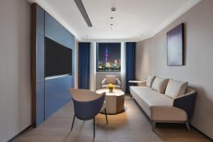 a living room with a couch and a table at JinglaiHotel Bushe Shanghai Bund Branch in Shanghai