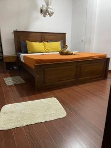 a bedroom with a wooden bed with yellow pillows and a rug at The Ceylan Crest Hotel Ella in Ella