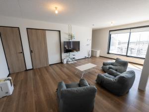a living room with two chairs and a tv at Rockstar Villa 尾崎浜STYLE in Awaji