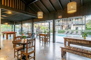 a restaurant with tables and chairs and a pool at Pousada Rosa 08 - Café da manhã Gourmet, Suítes com Banheira a 150m do Centrinho da Praia do Rosa in Praia do Rosa