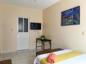a bedroom with a bed and a tv on the wall at Casa Dolores in Dolores Hidalgo