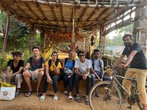een groep mensen die poseren voor een foto onder een houten constructie bij Time Travellers in Auroville