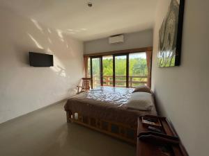 a bedroom with a bed and a large window at Karmani Villa Managed by Alyssa Villa Management in Ujung