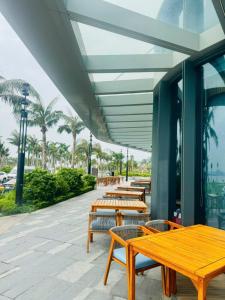 下龙湾À Là cart studio apartment with bay view and water music的楼外一排木桌和长椅