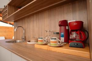 a kitchen counter with a coffee maker and coffee cups at Namora Domo Experience in Cajamarca