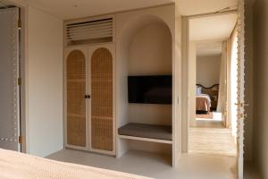 ein Schlafzimmer mit Einbauschrank und Fernseher in der Unterkunft The Huntley Villas Canggu in Canggu