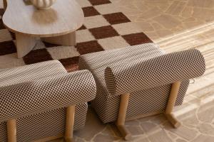 2 Stühle und ein Tisch in einem Zimmer mit kariertem Boden in der Unterkunft The Huntley Villas Canggu in Canggu