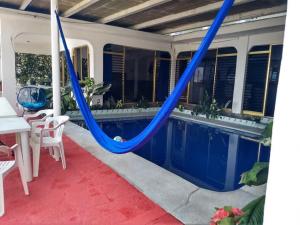 a blue hammock on a patio with a pool at Casa Vacacional Chula Vista in Acapulco