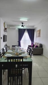 a dining room with a table and a couch at Alanis Suite KLIA With Neflix in Sepang