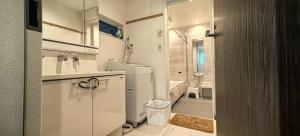 een kleine witte badkamer met een wastafel en een toilet bij KamakurakoshigoeekimaeA in Kamakura +40 foto's