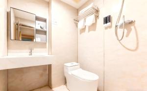 a bathroom with a toilet and a sink and a shower at Baiyuan Hotel Changgang Baogang Avenue Metro Station Branch in Guangzhou