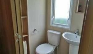 a small bathroom with a toilet and a sink at E67 DURDLE DOOR Ref 11663 in Wareham