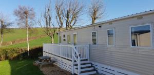 a white tiny house with a porch and stairs at E67 DURDLE DOOR Ref 11663 in Wareham