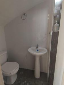 a white bathroom with a toilet and a sink at Casa ubicada en zona campestre de Ibagué in Ibagué