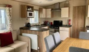 a kitchen with a couch and a table in a room at E67 DURDLE DOOR Ref 11663 in Wareham