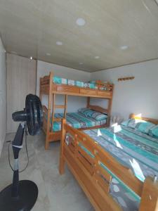 a bedroom with two bunk beds and a fan at Casa ubicada en zona campestre de Ibagué in Ibagué