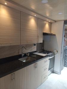 a kitchen with wooden cabinets and a sink and a stove at Casa ubicada en zona campestre de Ibagué in Ibagué +11 photos