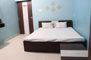 a bed with white sheets and pillows in a room at OYO 86877 Hotel Bhuneshwar Inn in Rāmgarh