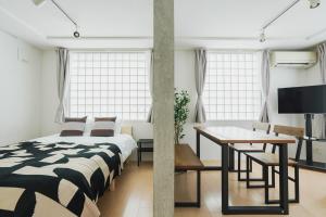 ein Schlafzimmer mit einem Bett, einem Tisch und einem Schreibtisch in der Unterkunft Ｂｒａｎｃｈｅ住吉ＥＡＳＴ in Fukuoka