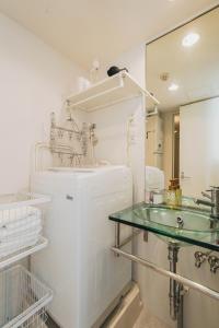 ein Badezimmer mit Waschbecken und Glastisch in der Unterkunft Ｂｒａｎｃｈｅ住吉ＥＡＳＴ in Fukuoka
