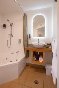 a bathroom with a sink and a tub and a mirror at Tussock Peak Lodge in Hanmer Springs +126 photos
