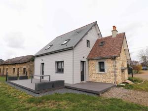 une maison blanche avec une terrasse devant elle dans l'établissement Maison chaleureuse à Sainte-Opportune avec jardin et terrasse - FR-1-497-178, à Sainte-Opportune
